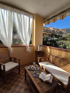 a room with two benches and a table and windows at Casa Naldina in Marciana Marina