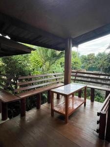 a porch with a table and benches on a deck at Thai Wooden Garden House By Paddy Fields Haven - Natures Nest in Pai