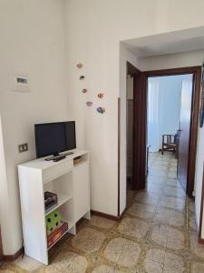 a living room with a tv on a white cabinet at Casa Naldina in Marciana Marina