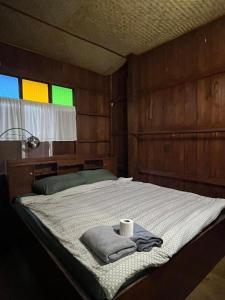 a bedroom with a bed with a towel on it at Thai Wooden Garden House By Paddy Fields Haven - Natures Nest in Pai
