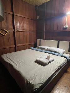 a bed with two towels and a cup on it at Thai Wooden Garden House By Paddy Fields Haven - Natures Nest in Pai