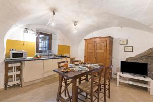 Una cocina con una mesa y sillas en una habitación. en La Casetta Del Borgo - Happy Rentals, en Usseaux