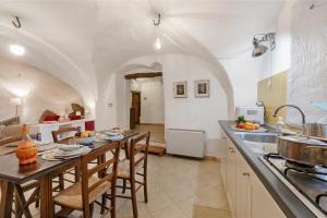 Una cocina con una mesa con sillas y una encimera. en La Casetta Del Borgo - Happy Rentals, en Usseaux