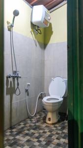 a bathroom with a toilet and a shower at Cokro Hinggil - Traditional View in Sleman +15 photos