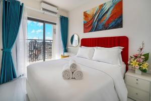a bedroom with a white bed and a large window at Otis Soho Saigon Balcony Apartment in Ho Chi Minh City