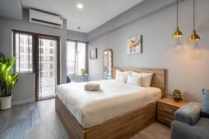 a bedroom with a large bed and a couch at Otis Soho Saigon Balcony Apartment in Ho Chi Minh City