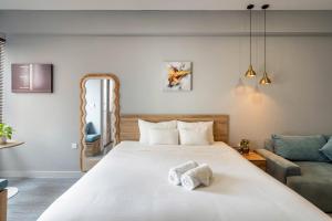 a bedroom with a large white bed and a couch at Otis Soho Saigon Balcony Apartment in Ho Chi Minh City