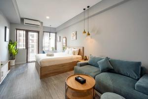 a living room with a bed and a couch at Otis Soho Saigon Balcony Apartment in Ho Chi Minh City