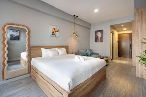 a bedroom with a large white bed in a room at Otis Soho Saigon Balcony Apartment in Ho Chi Minh City