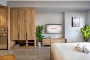 a bedroom with a bed and a tv on a wall at Otis Soho Saigon Balcony Apartment in Ho Chi Minh City