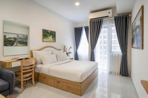 a bedroom with a bed and a desk and a chair at Otis Soho Saigon Balcony Apartment in Ho Chi Minh City