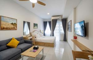 a living room with a couch and a bed at Otis Soho Saigon Balcony Apartment in Ho Chi Minh City