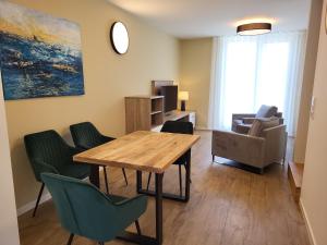 a living room with a wooden table and chairs at Hafen 15 - Ihre Ferienwohnung im Hafen am Geiseltalsee in Mücheln
