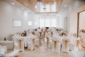 a room with white tables and chairs in a room at Nostalgia restaurant & pension in Rimavská Sobota