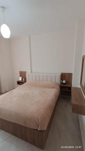 a bedroom with a large bed and two tables at ILSA Apartment in Durrës