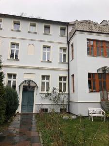 una casa blanca con una puerta azul y un patio en Sands Sopot Apartments 1, en Sopot