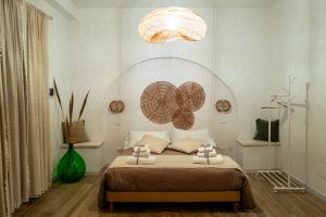 a bedroom with a bed and a chandelier at Dimore Piazza Vecchia Wellness Suites in Castellana Grotte