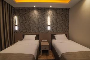 two beds in a small room with two lamps at Huzur Apart Hotel in Istanbul