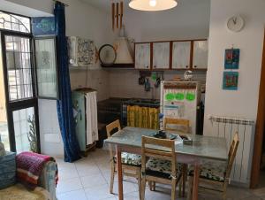 a kitchen with a table and chairs and a refrigerator at Little art house in Gaeta +24 photos