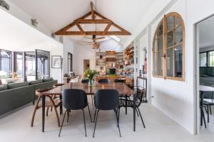 a dining room with a wooden table and chairs at Demeure d'exception vue mer in Andernos-les-Bains