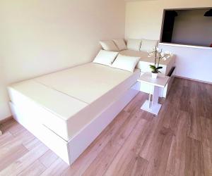 białe łóżko w pokoju z telewizorem w obiekcie Jacuzzi and Pool Apartments w mieście Matulji +37 zdjęć
