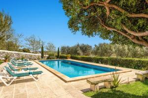 a swimming pool with lounge chairs and a tree at Finca Llucasaldent Menor by Menorca Vacations in Alaior