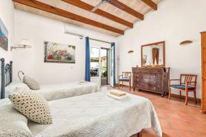 a room with two beds and a dresser in it at Finca Llucasaldent Menor by Menorca Vacations in Alaior +20 photos