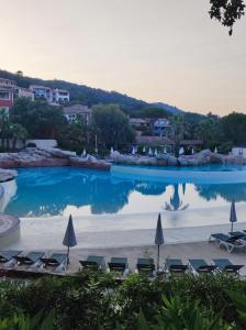 a large swimming pool with chairs and umbrellas at Villa Solenzaïa in Grimaud