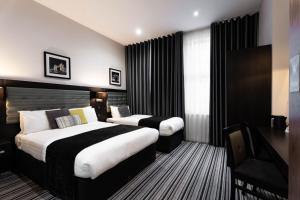 伦敦The W14 Kensington的一间有两张床和一台电视的酒店房间