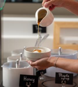 a person is pouring coffee into a bowl at Oniro Boutique Hotel in Toroni
