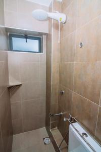 a bathroom with a shower with a glass door at Miiza Realtors in Nairobi +35 photos