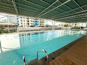 a large swimming pool with blue water in a building at Abreeza Place Cozy Condo in Davao City