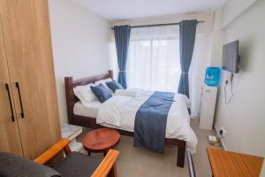 a bedroom with a bed and a table and a window at Miiza Realtors in Nairobi