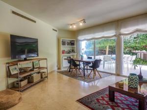 Una sala de estar con una mesa y un televisor. en Luxury Seaview Apartment by Hello Homes Sitges, en Sitges