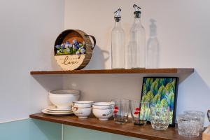 a shelf with glass bottles and bowls on it at Otis Soho Saigon Balcony Apartment in Ho Chi Minh City