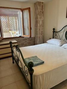a bedroom with a large bed with a window at Villaliana in Torre Dei Corsari