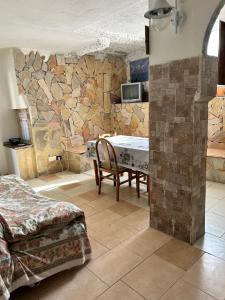 a room with a table and a stone wall at Villaliana in Torre Dei Corsari