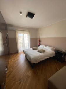 a bedroom with a large white bed and wooden floors at casa picasso in Naples