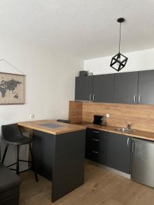 a kitchen with black cabinets and a wooden counter top at SOBE DELUX Vodice in Vodice