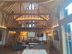 a living room with a large wooden ceiling at Low Farm Barn, a family and dog friendly haven in Brundish +30 photos