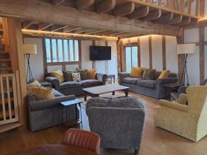 a large living room with couches and a table at Low Farm Barn, a family and dog friendly haven in Brundish