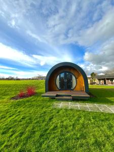 a small building in the middle of a field at Rowan Hobbit Pod at Cowbridge Cabins in Cowbridge +18 photos
