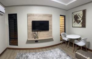 a living room with a tv and a table and chairs at charming retreat in Gaborone