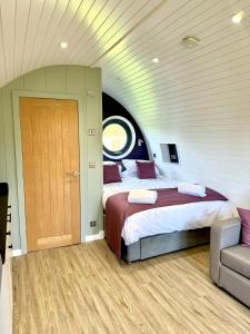 a bedroom with two beds and a door in it at Rowan Hobbit Pod at Cowbridge Cabins in Cowbridge