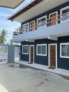 a blue and white house with a balcony at Atalaia Suítes in Salinópolis