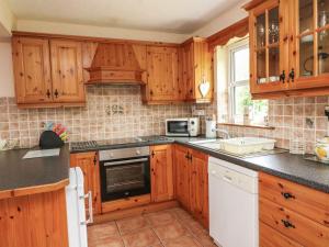 una cucina con mobili in legno e un forno a piano cottura di 18 Dalewood a Glengarriff