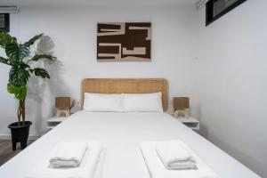 Un dormitorio con una cama con sábanas blancas y una planta en VLC Host - Tamarit, en Valencia