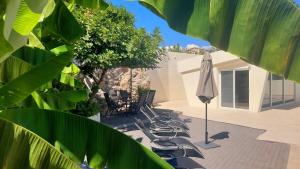 grupa krzeseł i parasol na patio w obiekcie Jacuzzi and Pool Apartments w mieście Matulji