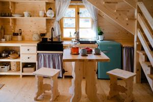 a kitchen with a wooden table in a cabin at Sopki Stopki Polana Wspólna in Cięcina
