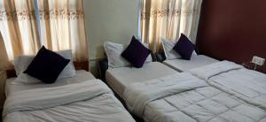 two beds sitting next to each other in a bedroom at Hotel Blue lake in Pokhara